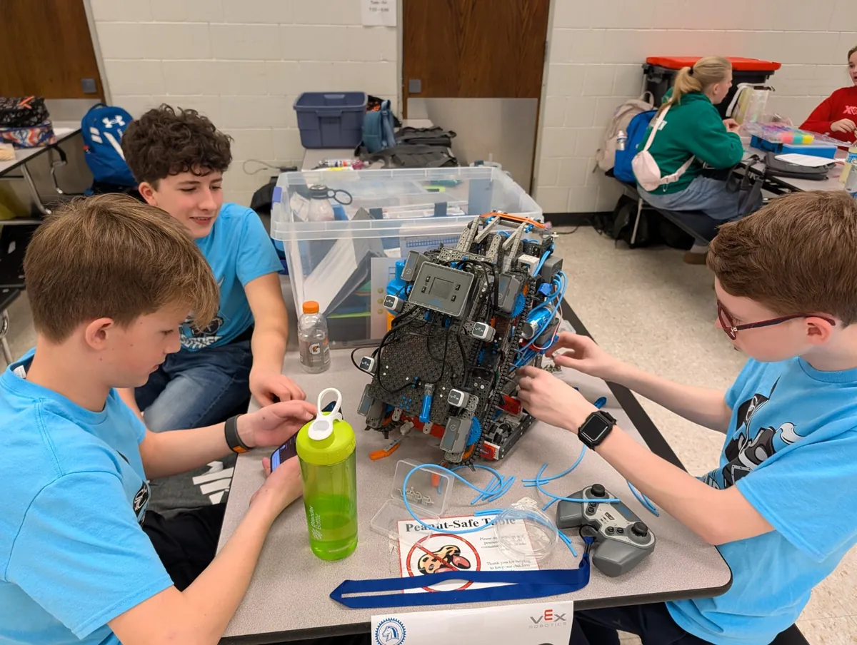 Students building a VEX IQ robot together at a table