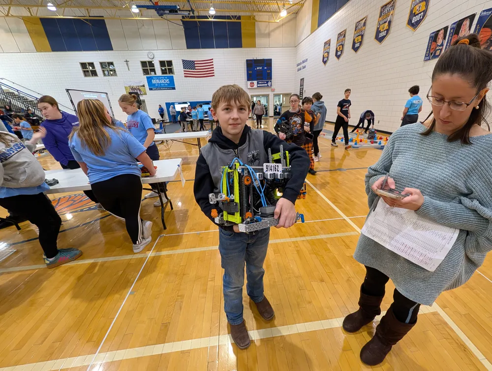 A student presenting their VEX IQ robot to a judge at a tournament
