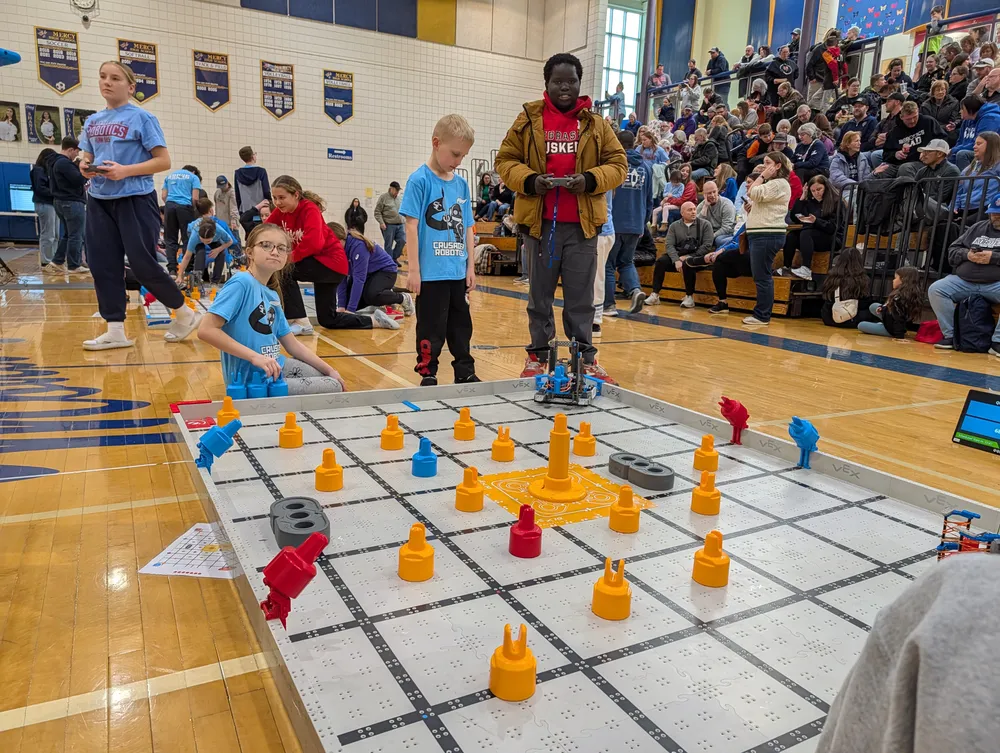 Officials overseeing VEX IQ matches on the competition floor at a tournament